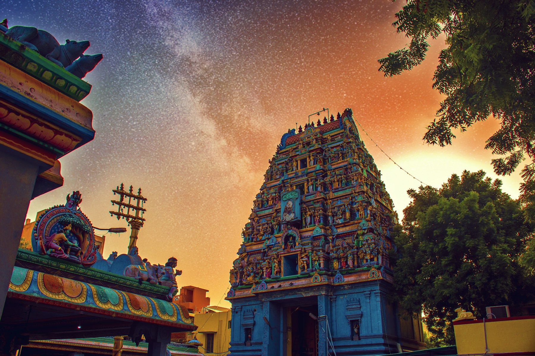 A carved Tamil temple gopuram rising against a night sky full of stars